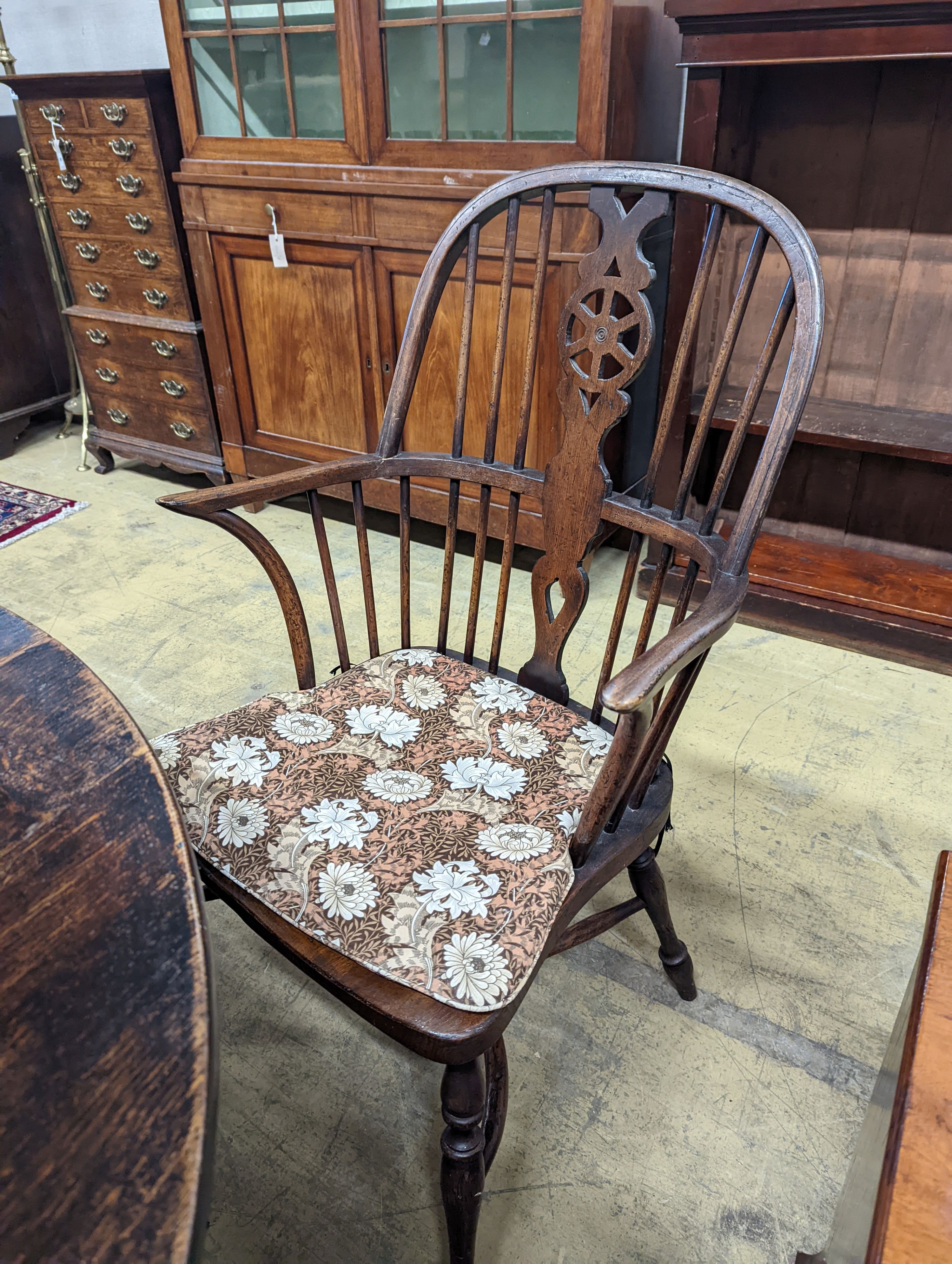 A wheelback Windsor elm and beech chair and six matching single chairs with crinoline stretchers, one with arms